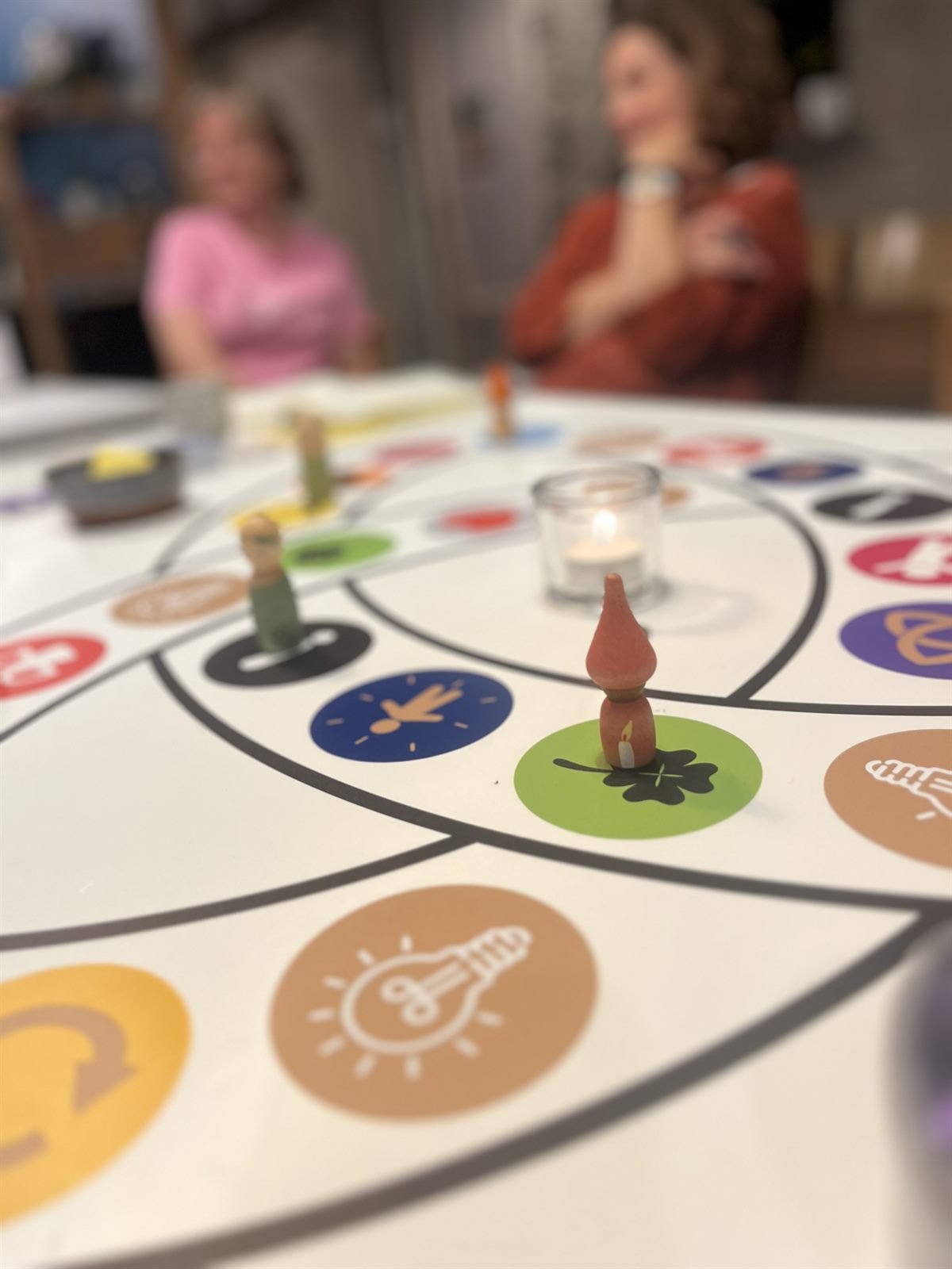 Het transformatieve spelbord van Ruimte voor Wending met houten pionnen en een kaarsje