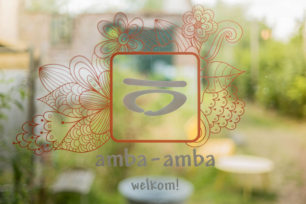 Het amba-amba-logo met 'welkom!' op het raam in Desselgem (Waregem)